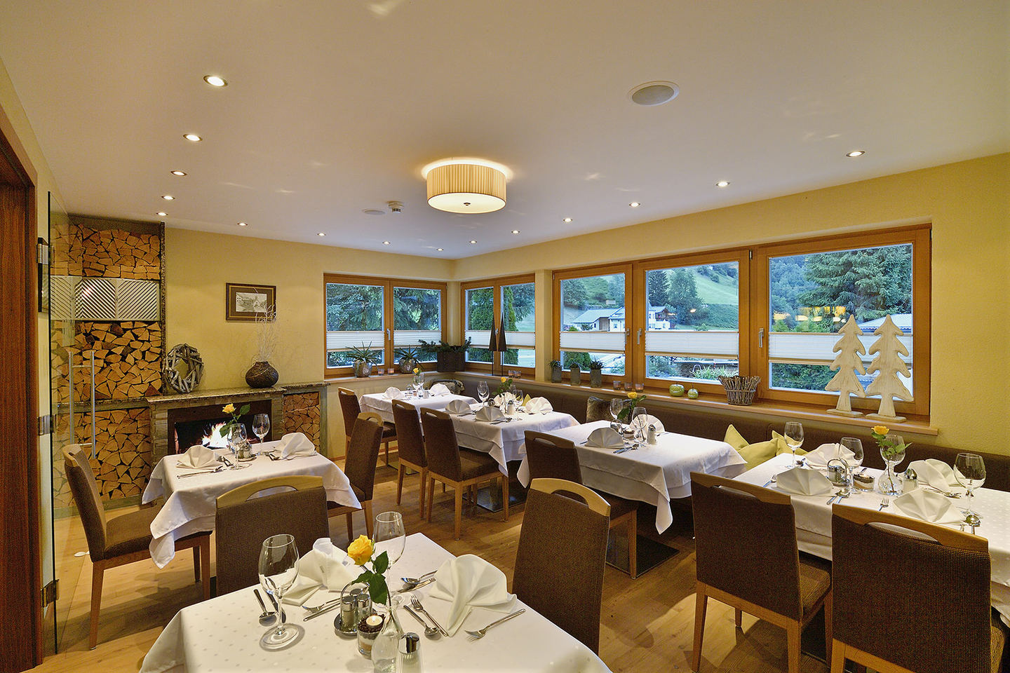 Restaurant with laid tables and a window front at Hotel Enzian