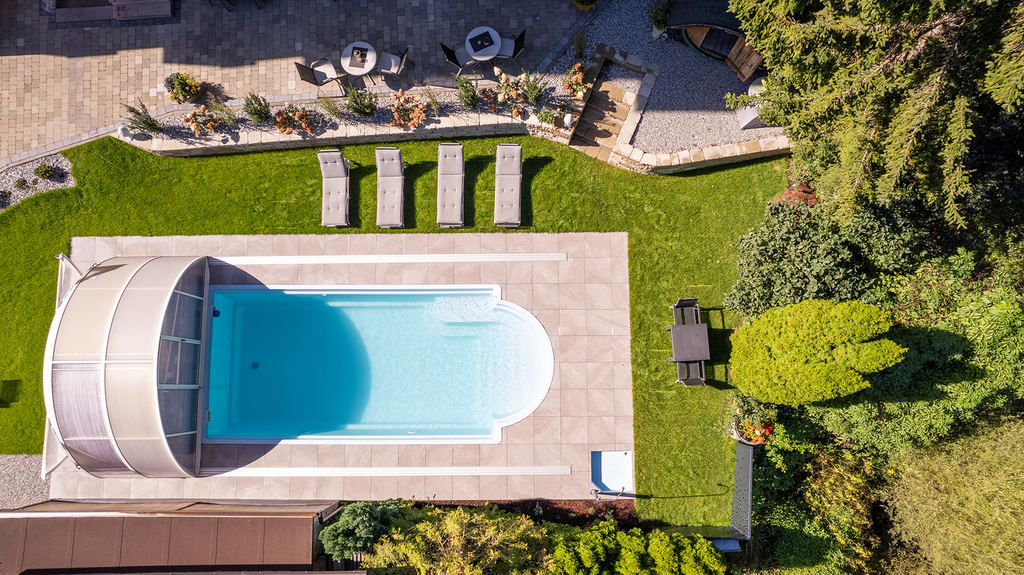 Luftaufnahme des Freibads mit Überdachung im Hotelgarten