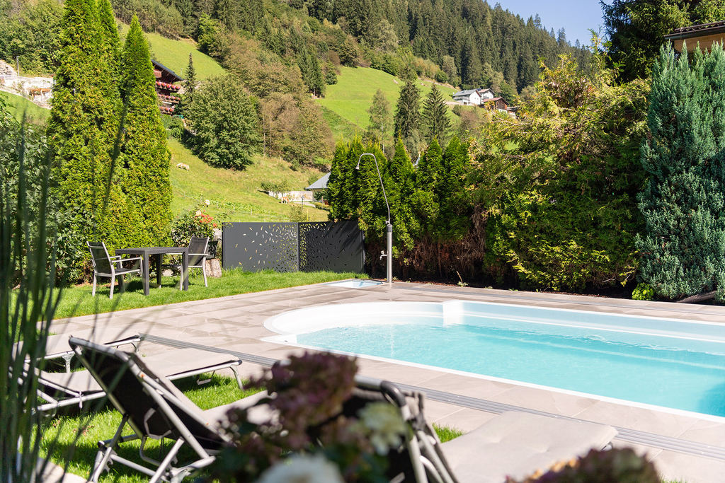 Freischwimmbad mit Liegen im Hotelgarten