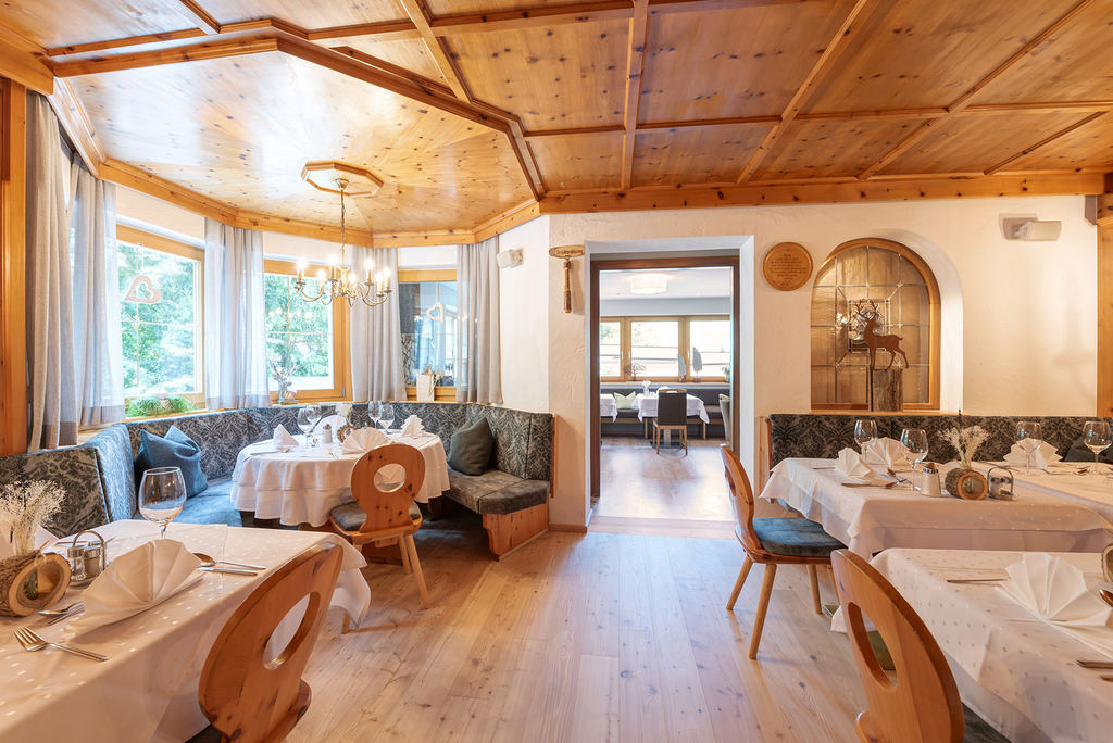 Stube mit gedeckten Tischen im Hotel Enzian